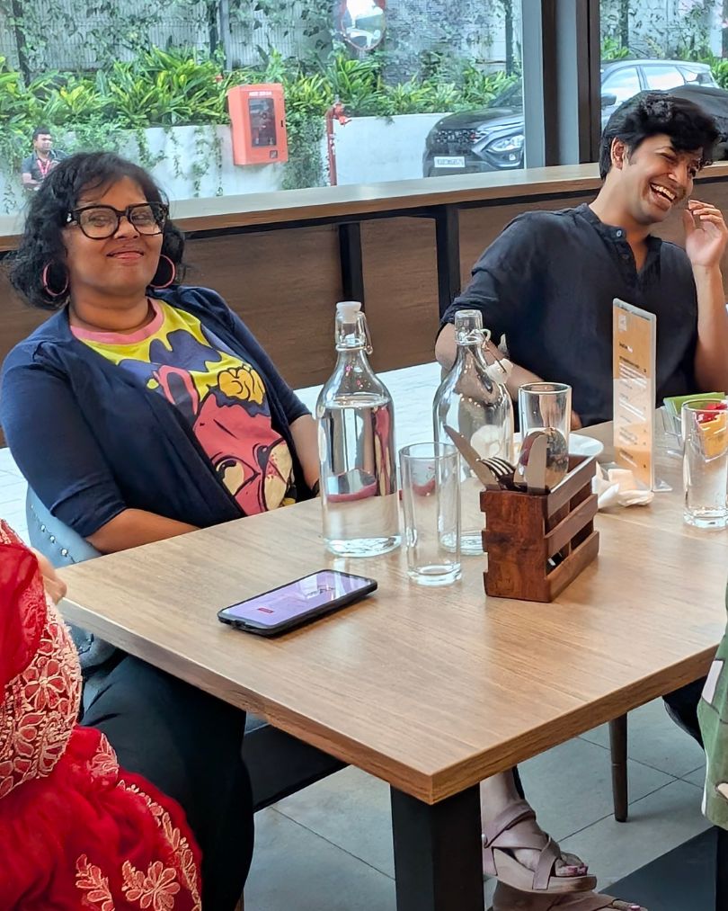 Six people sharing a prompt round at a somo club table
